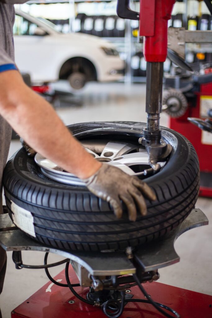 Garagiste fixant un pneu pour avoir la bonne pression de pneusur une jante dans un atelier mécanique
