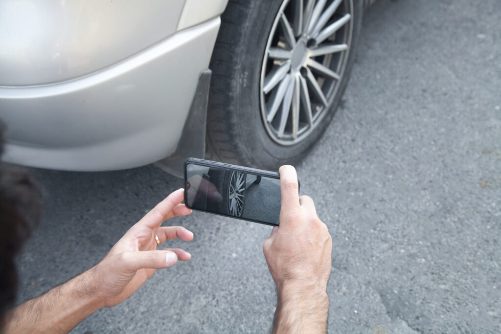 Homme prenant une photo d'une voiture sur son téléphone