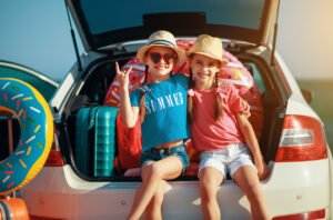Enfants heureux. Filles soeurs jumelles sur le trajet en voiture pour le voyage d'été